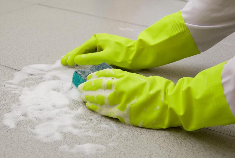 hand in gloves cleaning the floor